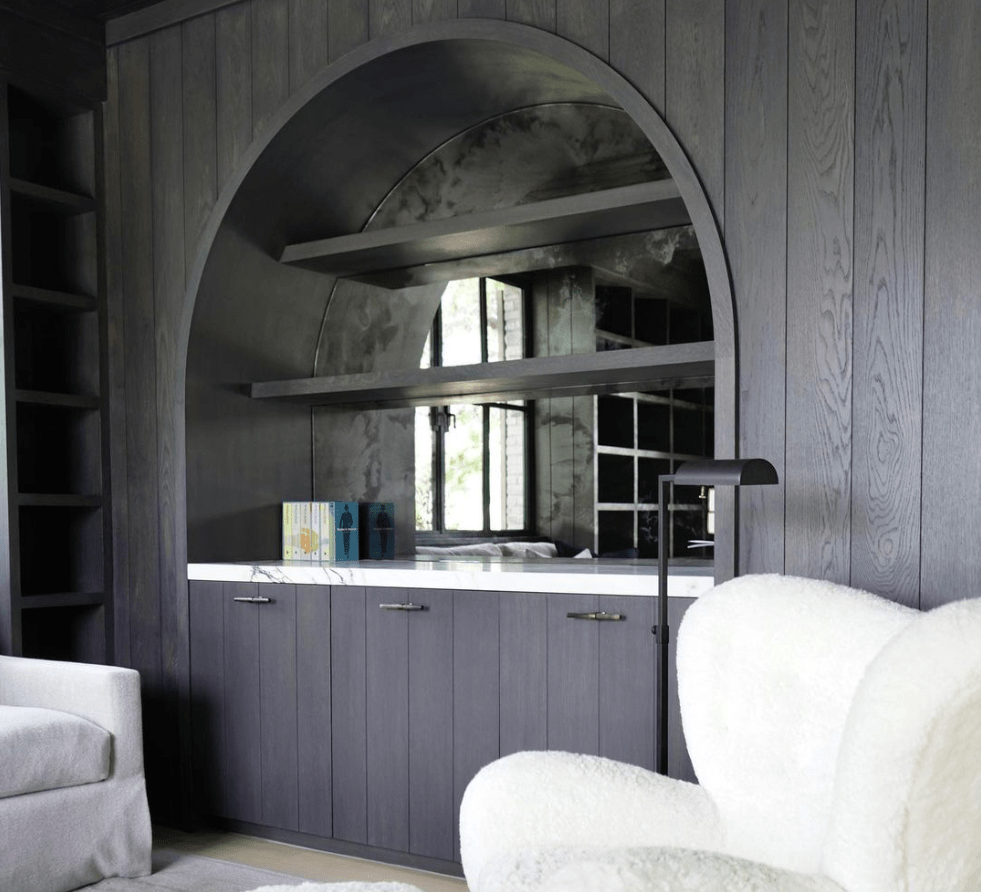 Custom arched built-in with dark charcoal paneling, antique mirror niche, and marble-top credenza, Newport Beach