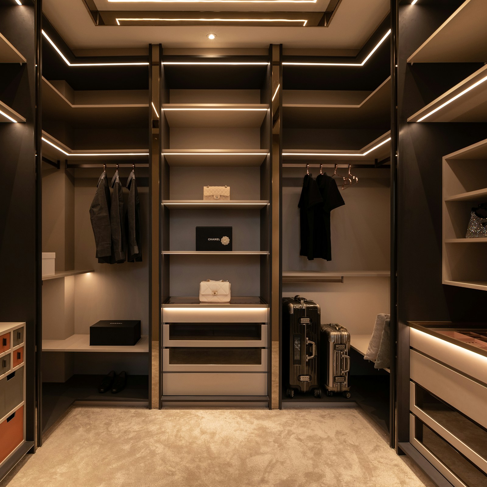 Custom walk-in closet with integrated island, drawers, and LED accent lighting