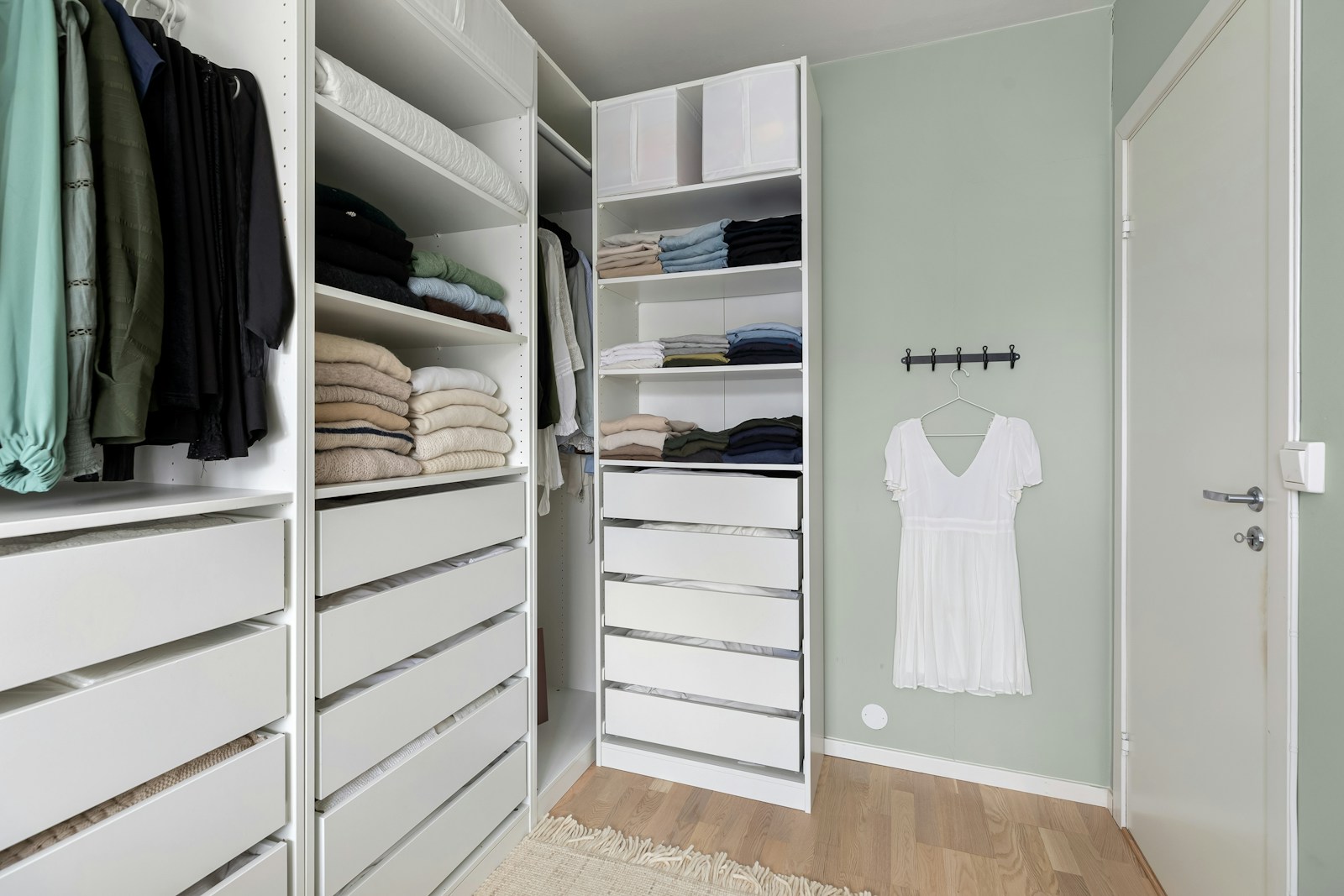 Custom white built-in closet system with drawer units and organized wardrobe