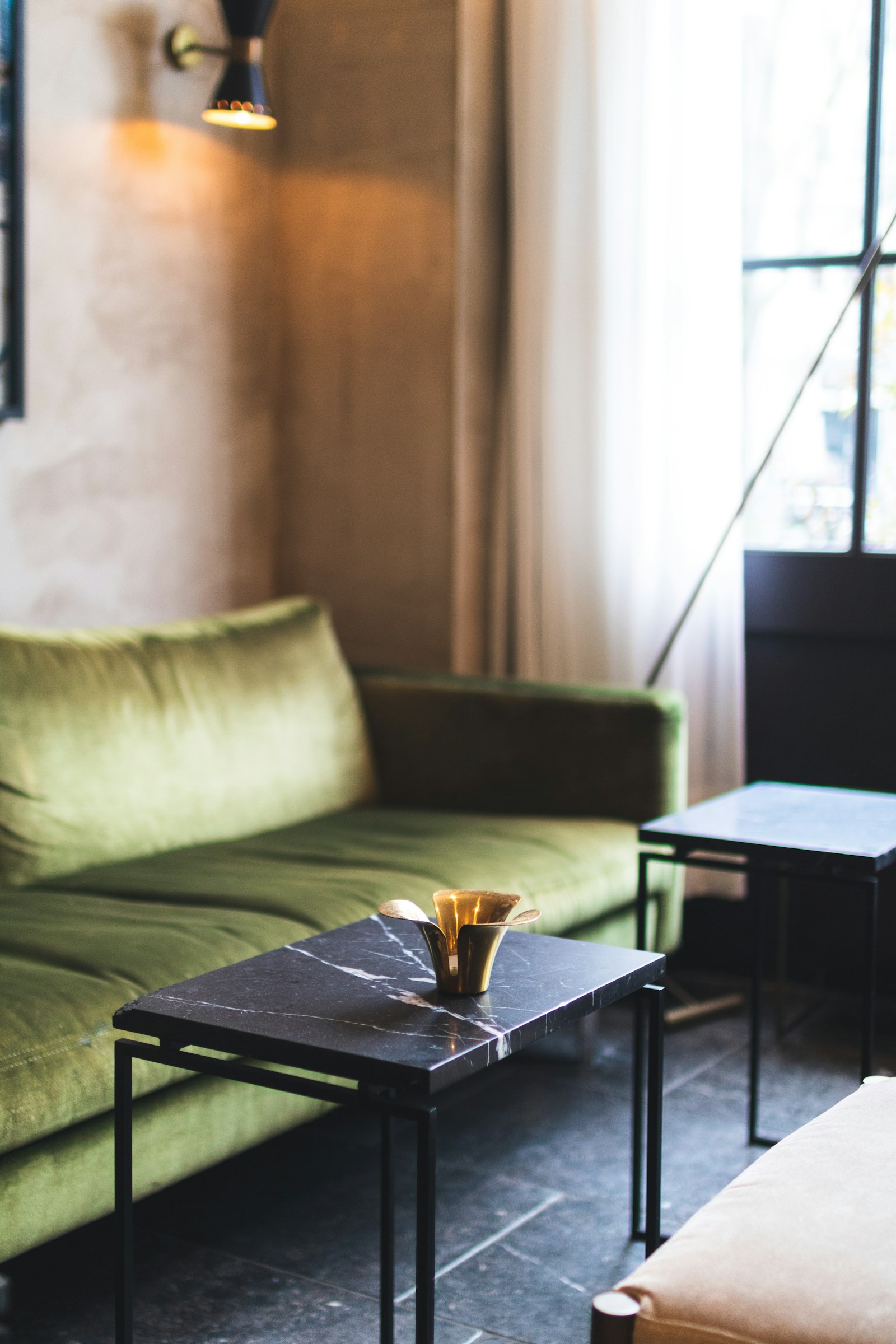 Luxury living room with marble-top coffee table and green velvet sofa seating