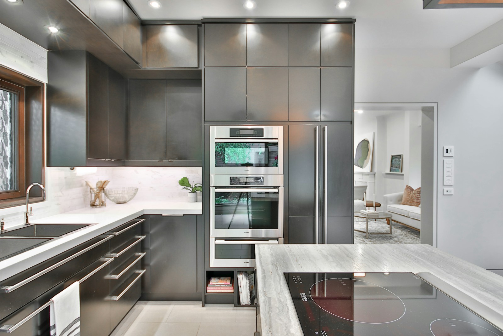 Sleek contemporary kitchen with black and gold hardware and marble countertops