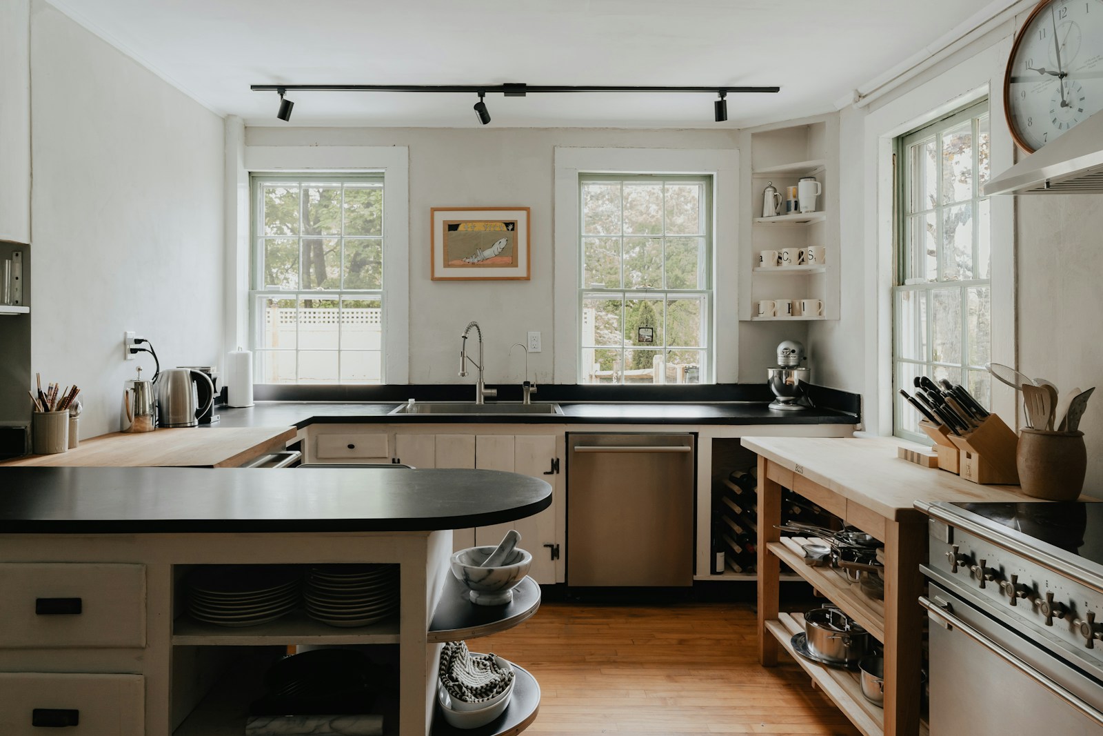 Cottage kitchen with painted cabinetry, wall clock, and warm residential character
