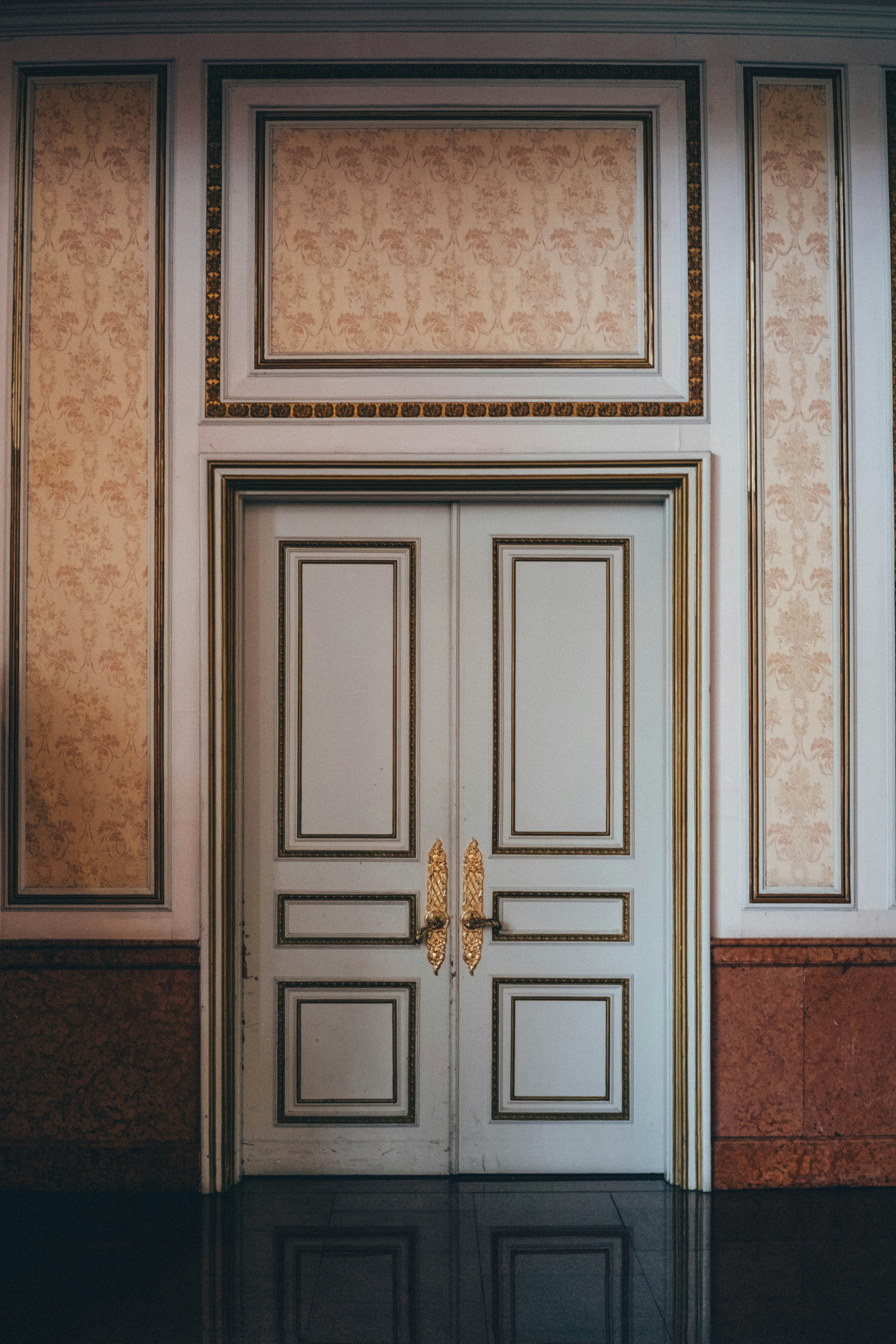Ornate solid wood entry door white painted raised panel molding gilded brass hardware