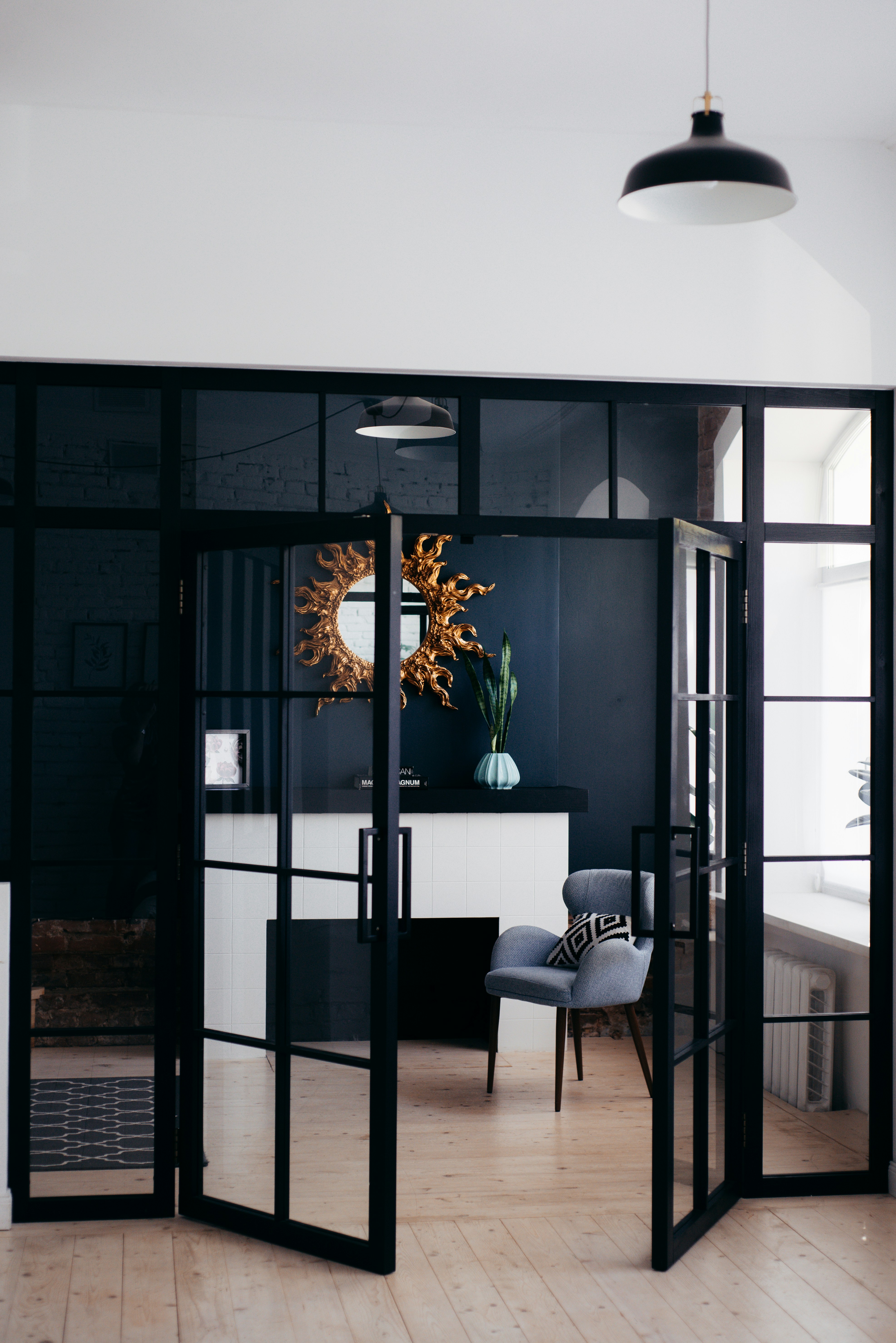 Contemporary black steel and glass interior French doors opening to a modern living space