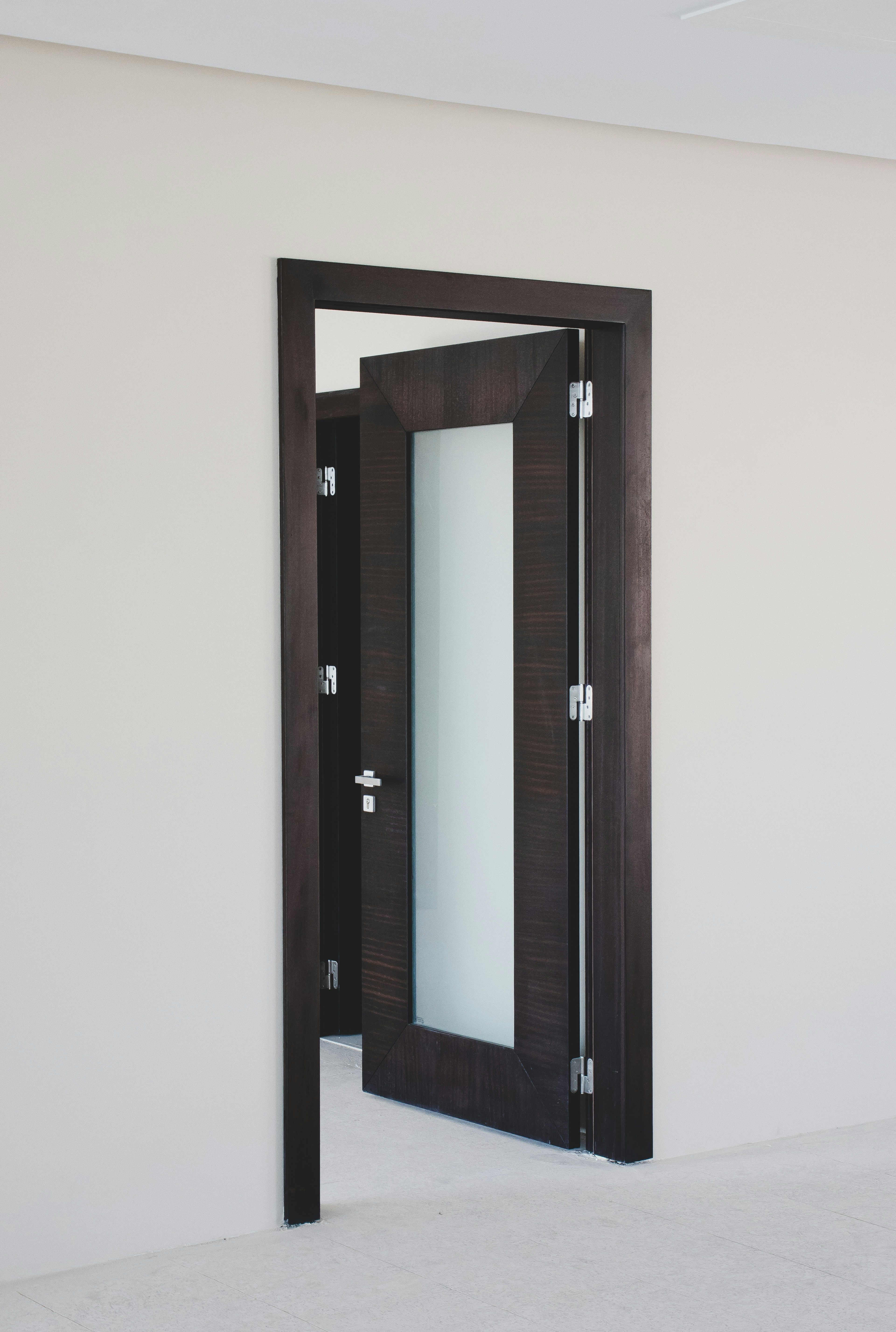 Custom dark wenge interior door with frosted glass panel inset and precision hardware