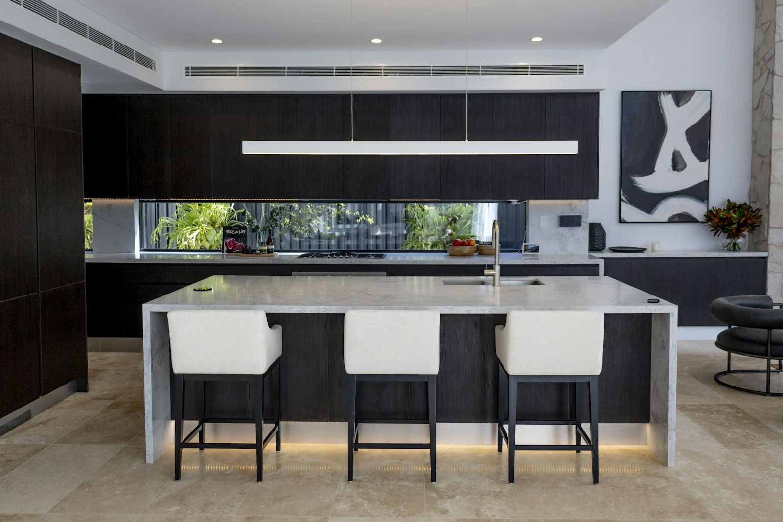 Contemporary dark kitchen with marble island and custom modern cabinetry