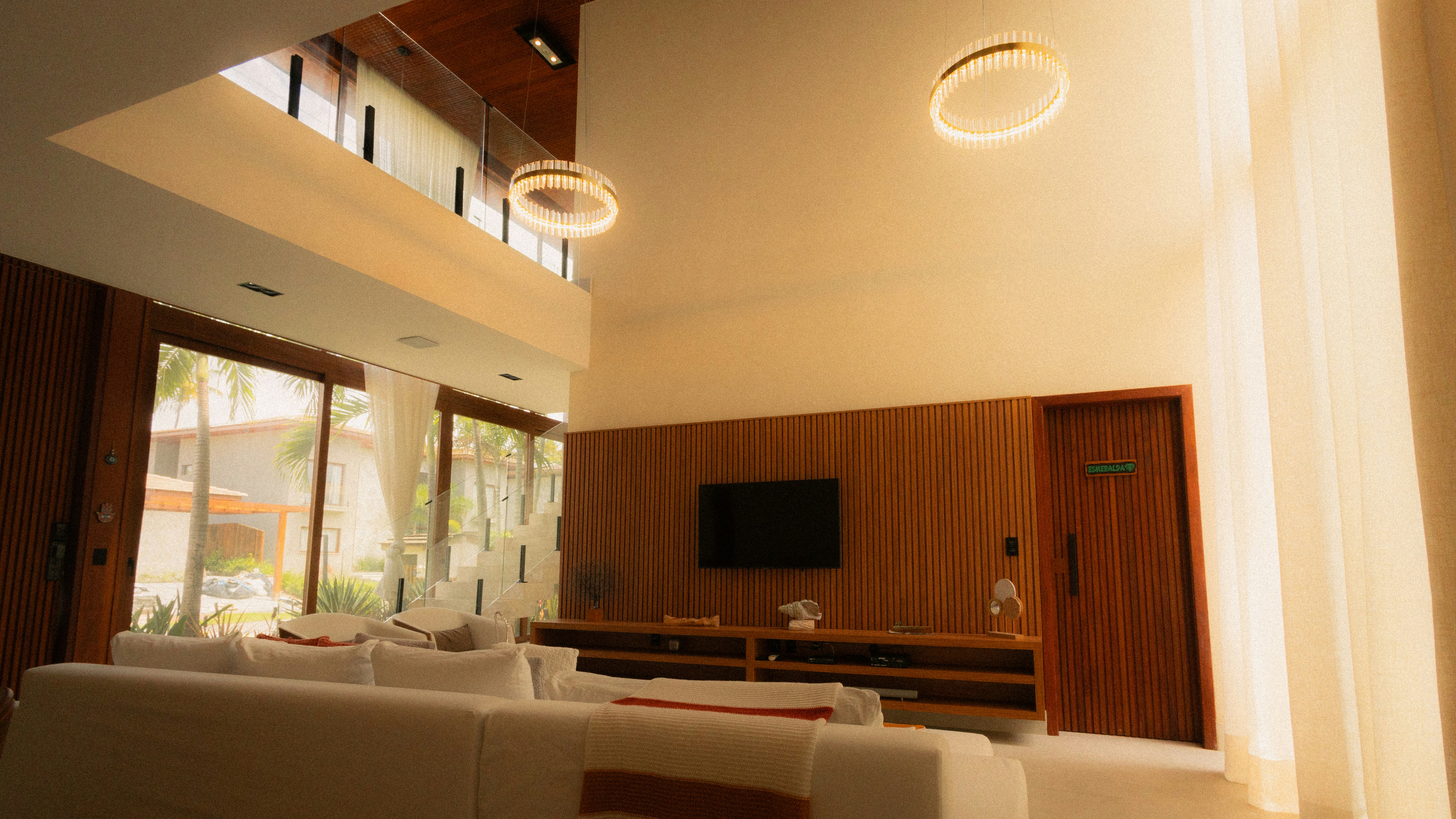 Custom wood slat wall integrated TV teak console vaulted ceiling luxury open plan