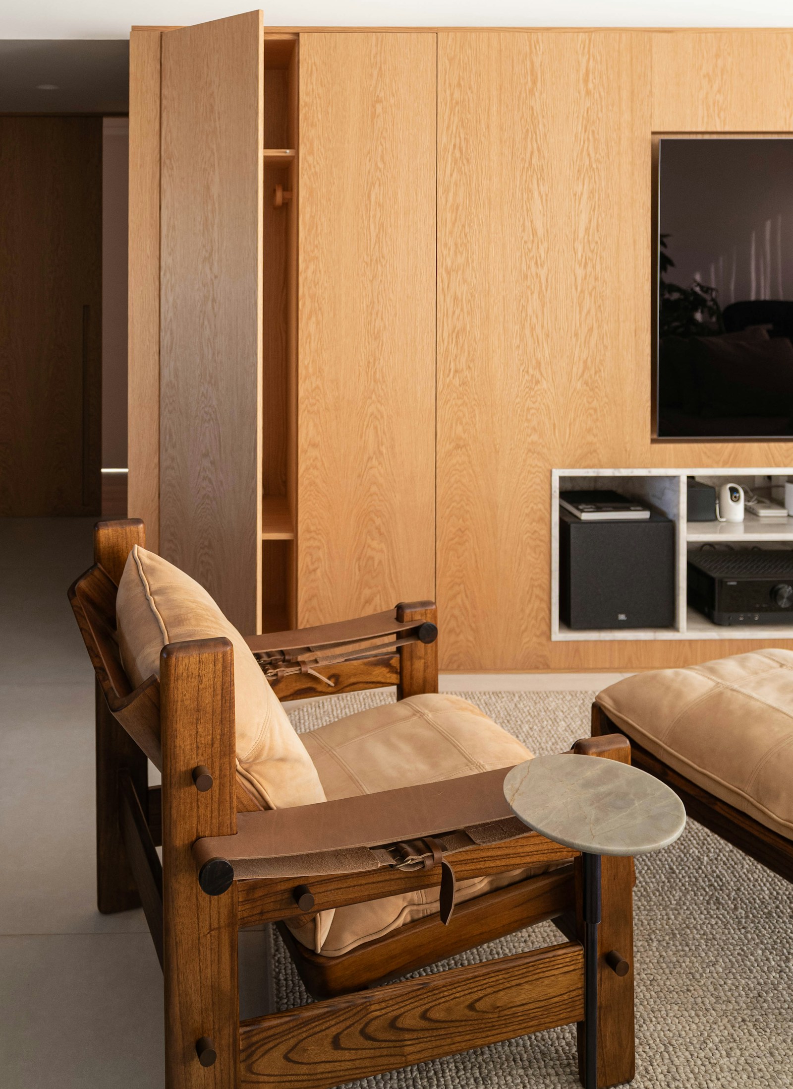 Custom oak wood built-in TV panel wall with concealed storage and open cabinetry