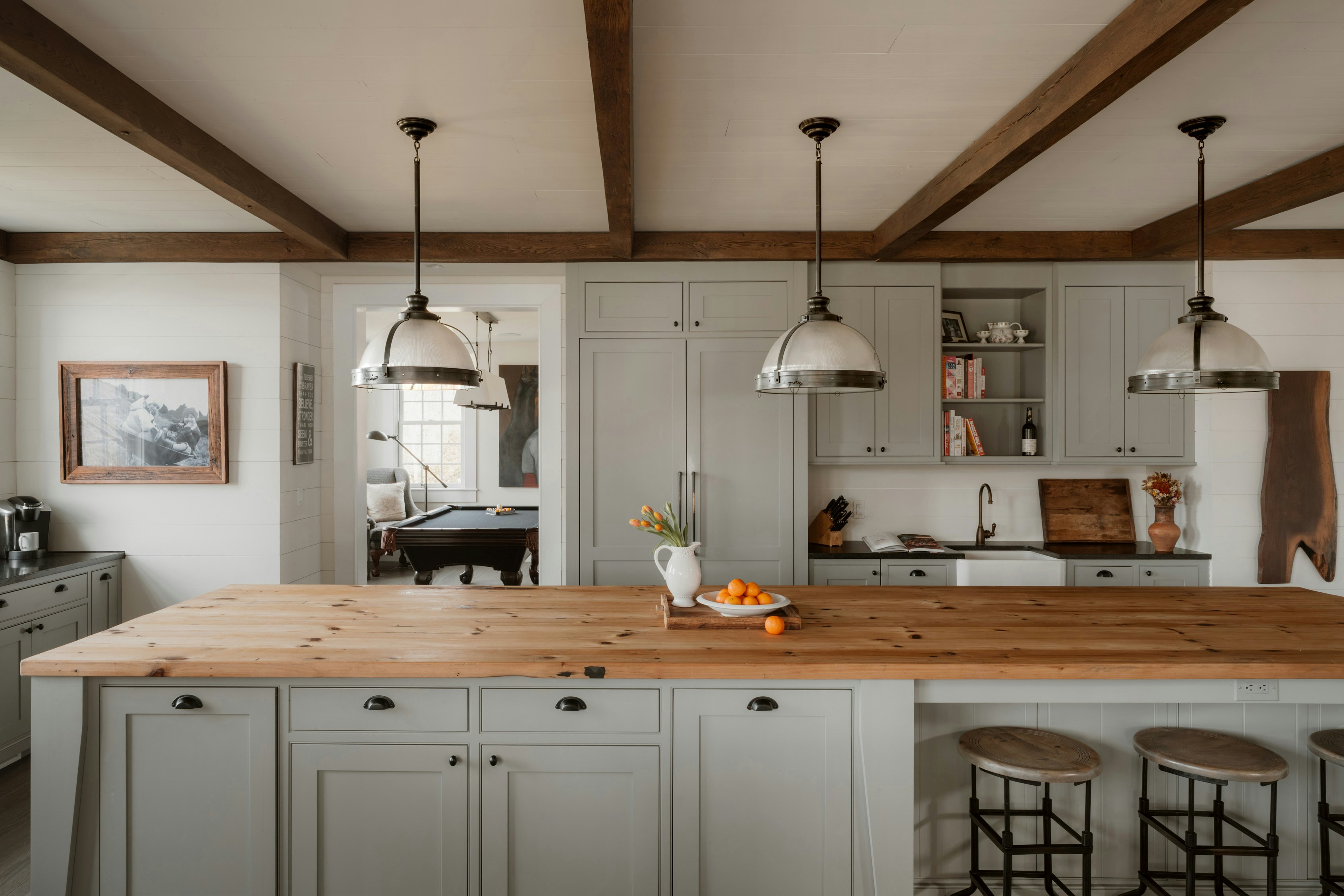 Rustic farmhouse kitchen exposed wood beams sage green cabinetry butcher block island