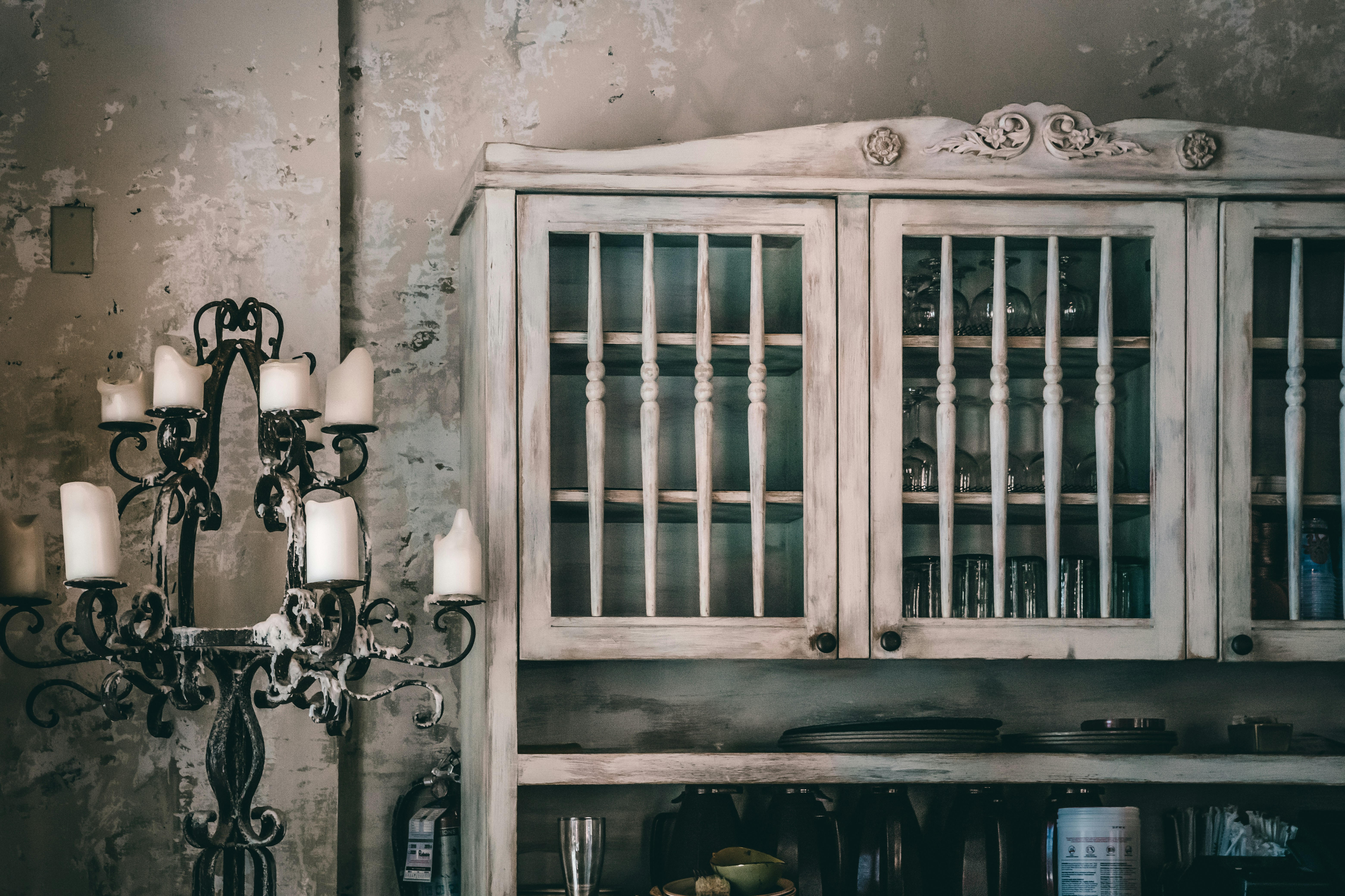 Shabby chic aged white cabinet glass doors iron candelabra moody vintage atmosphere