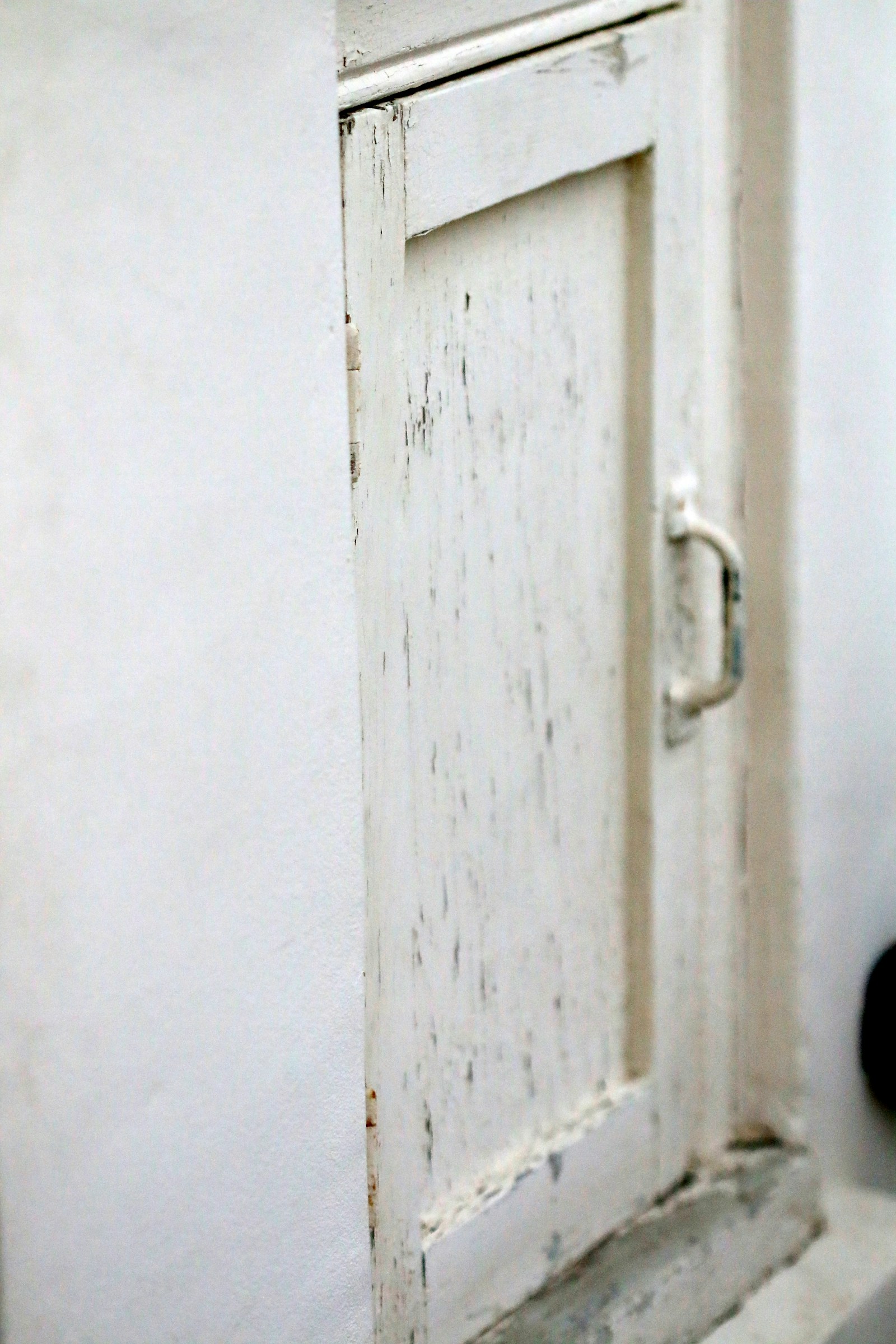 Distressed white shabby chic cabinet with weathered finish and vintage styling