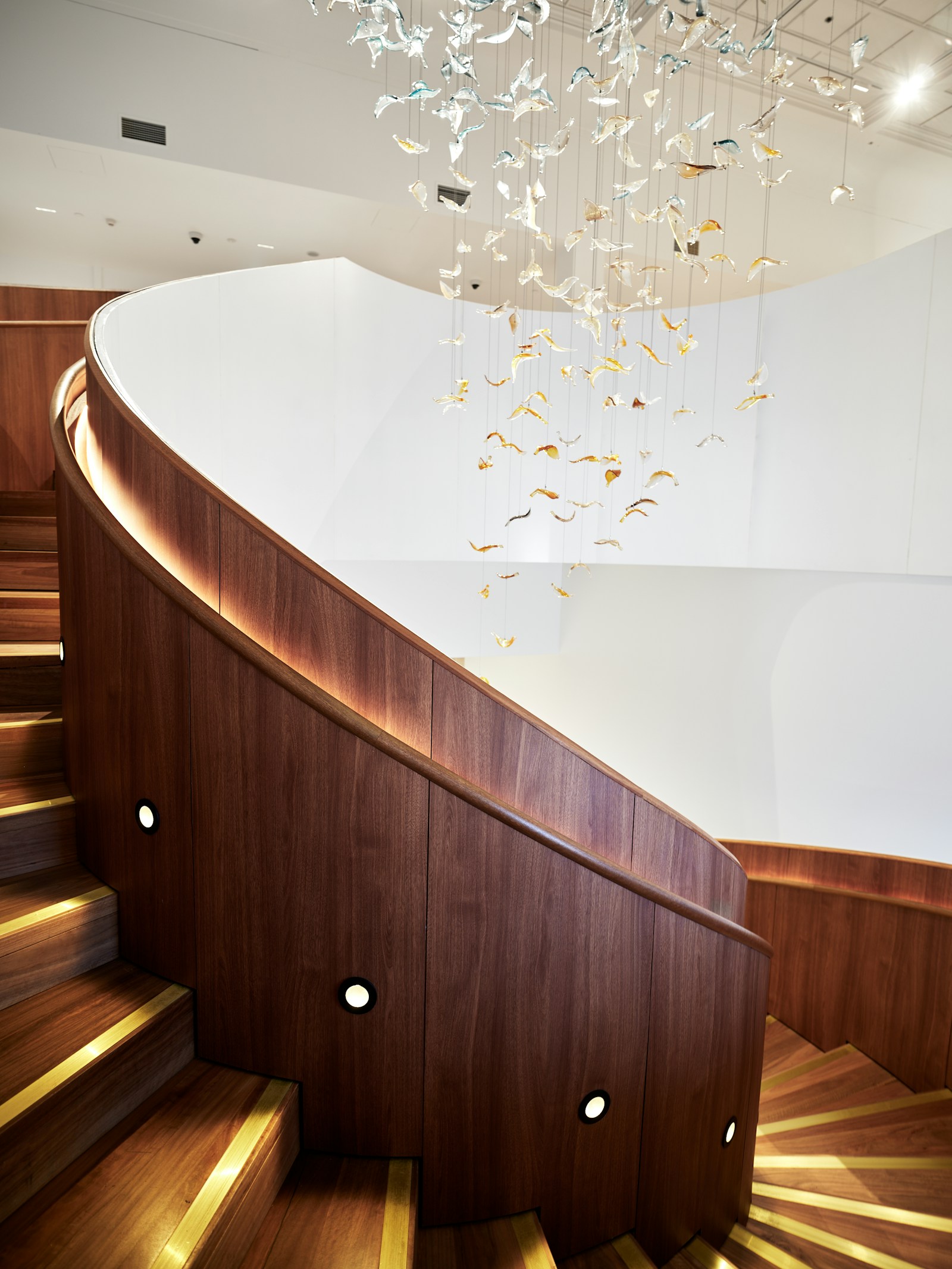 Custom luxury wood staircase with curved design and artisan carved railing