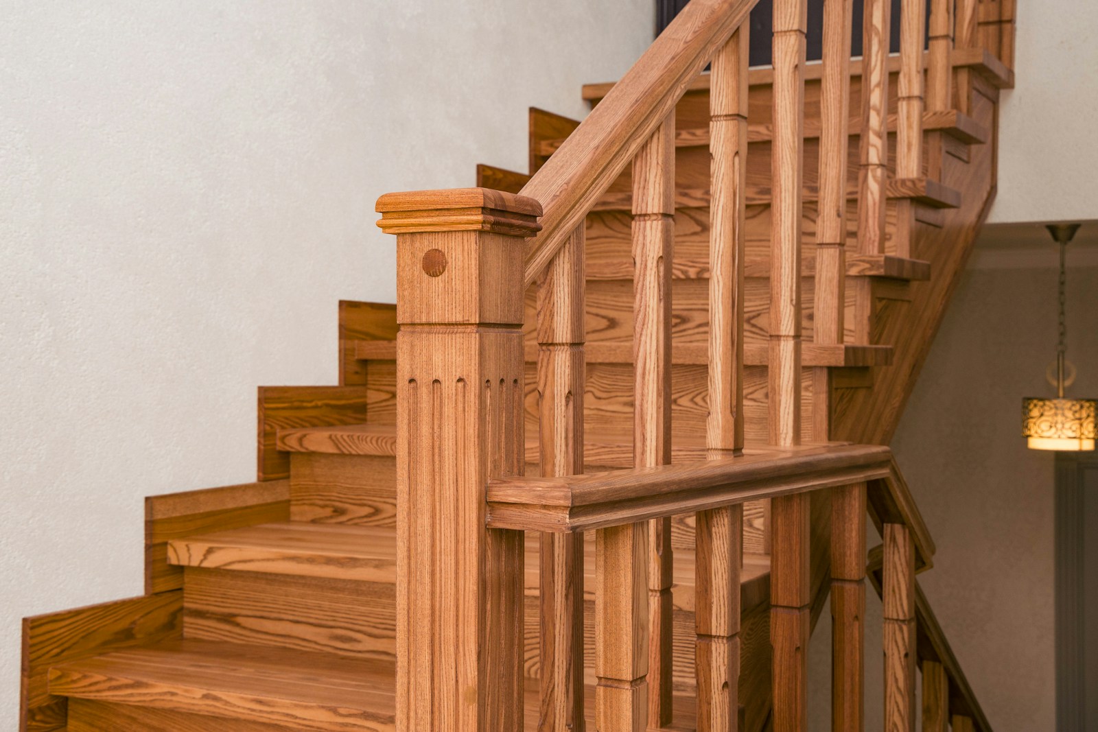 Classic custom wood staircase with turned balusters and ornate carved newel post
