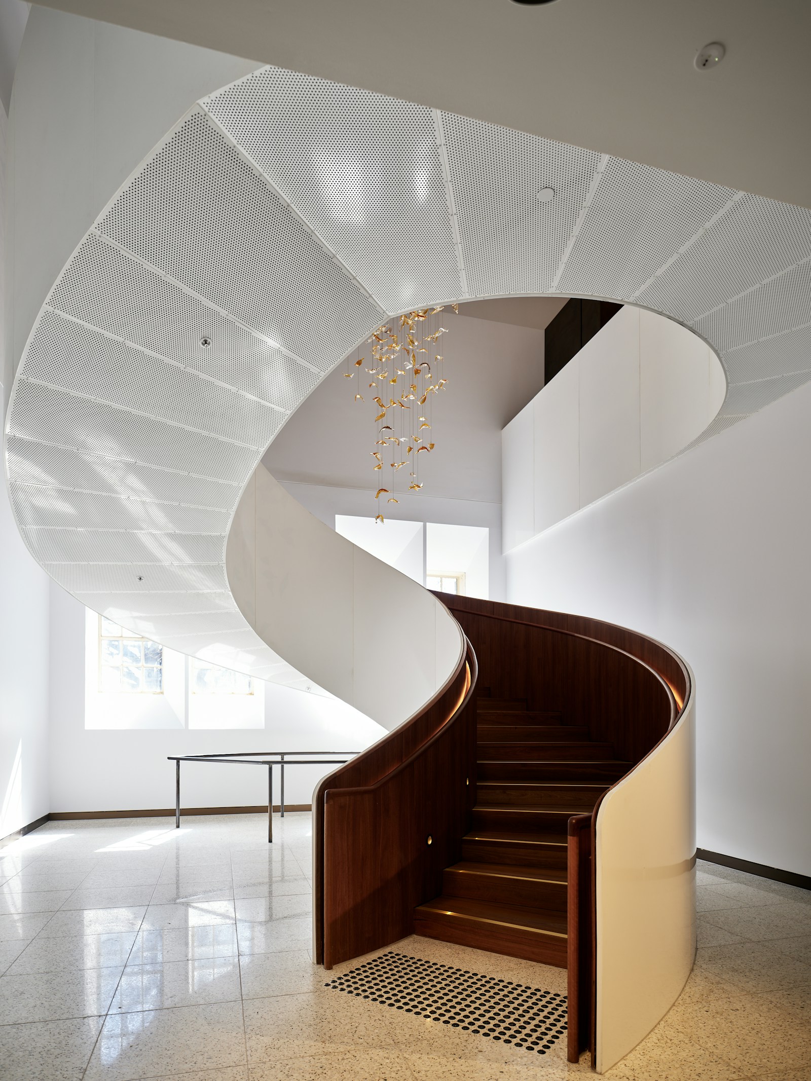 Luxury custom staircase with elegant curved design and rich wood species