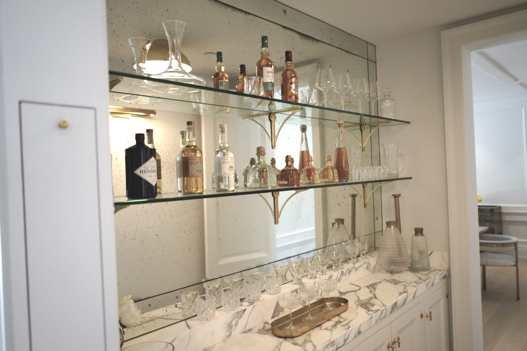Custom wet bar glass shelving marble countertop brass hardware