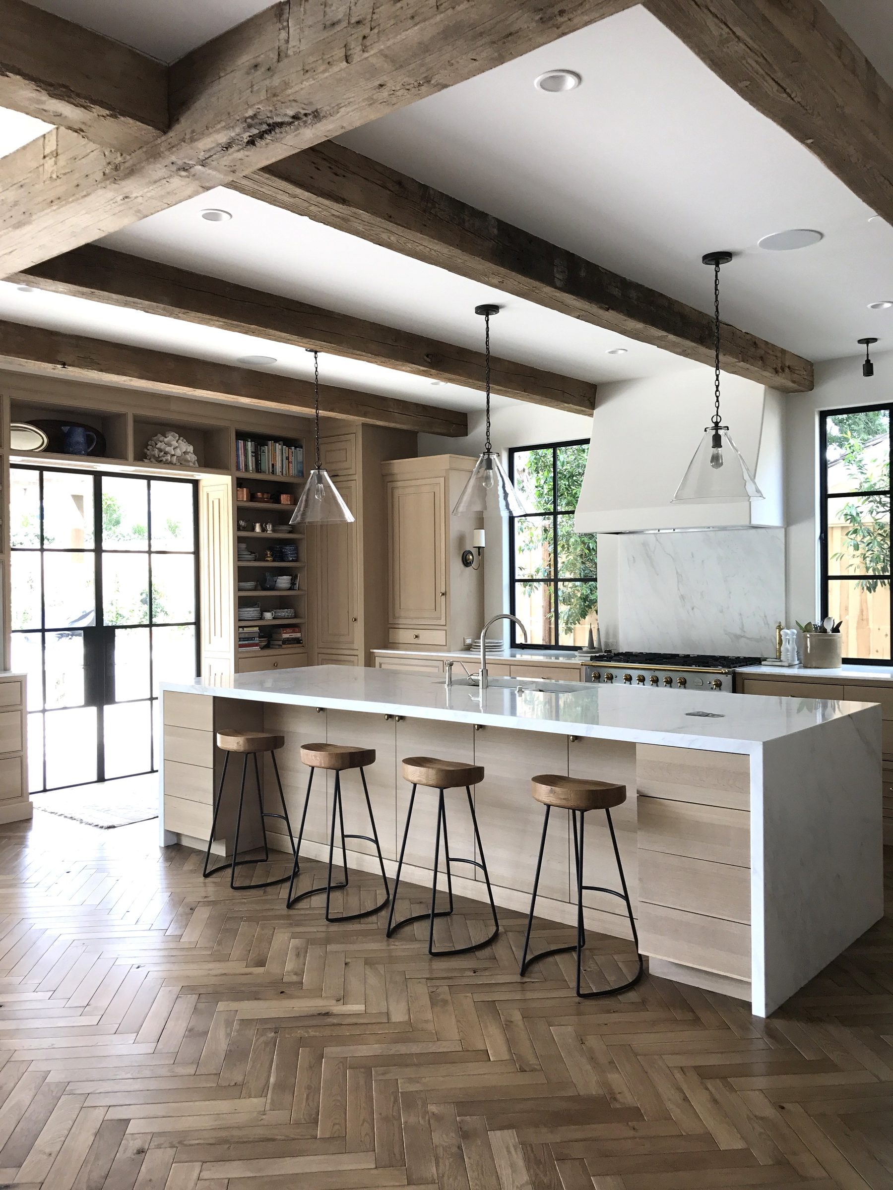 Cream kitchen cabinetry herringbone hardwood floor wide view