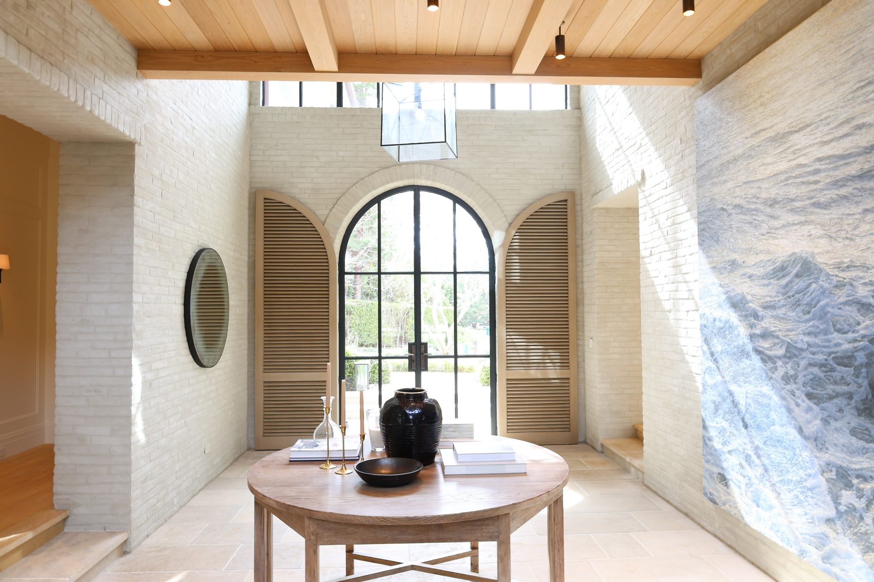 Custom arched wood louvered panel doors entry hall luxury home