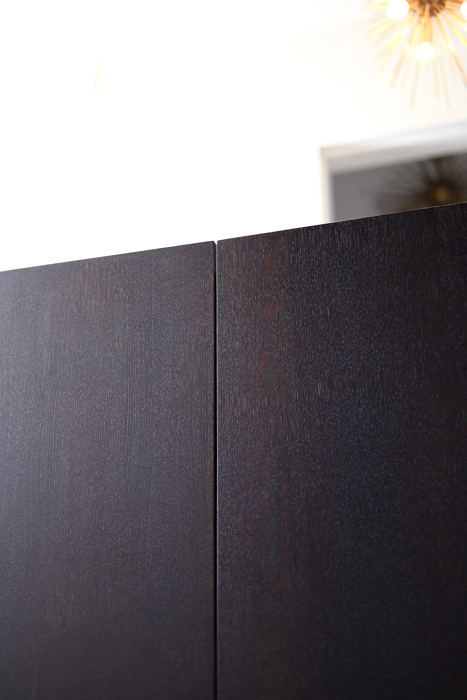 Custom dark oak cabinet door detail sputnik chandelier