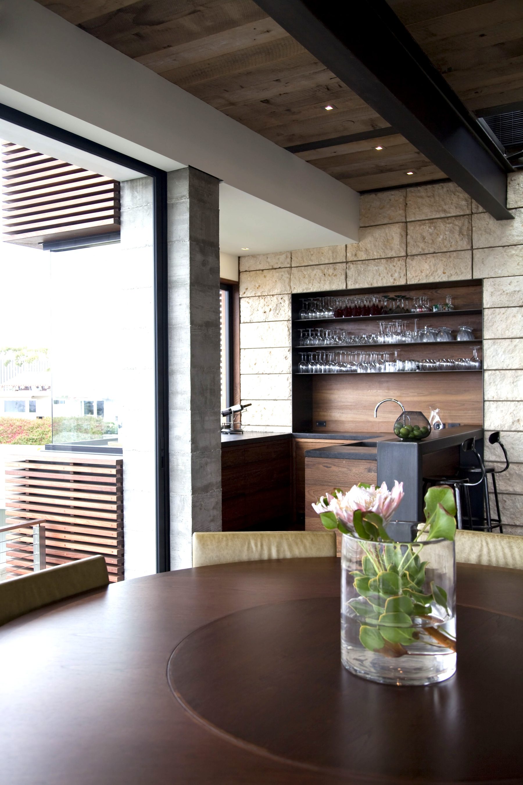 Custom built-in bar glass shelving stone wall Newport Beach