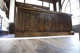 Ornate dark carved wood credenza front panel detail
