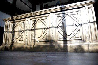 Custom carved cabinet panel dramatic shadow lighting detail