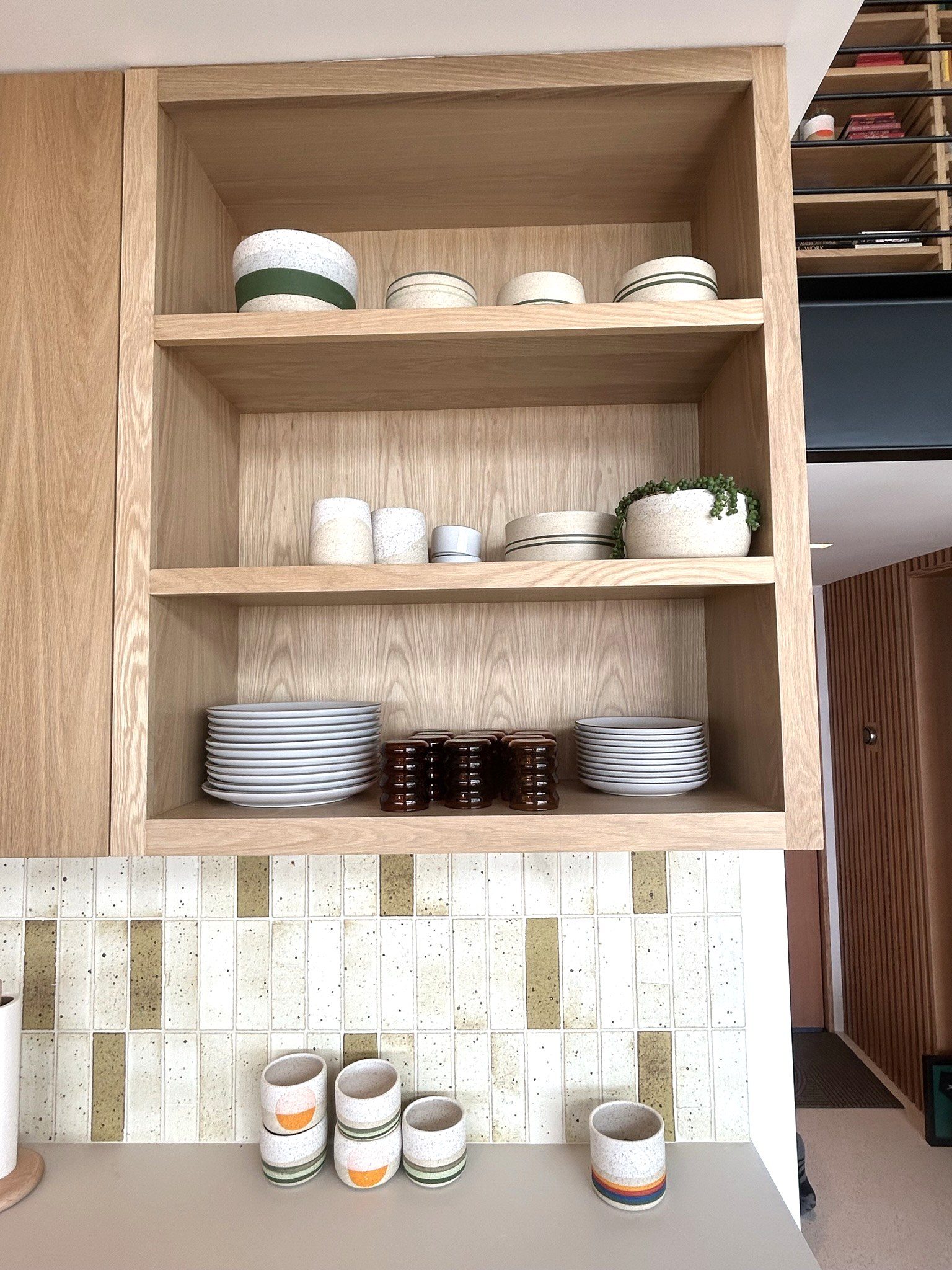 Custom white oak kitchen open shelving ceramic dishes detail