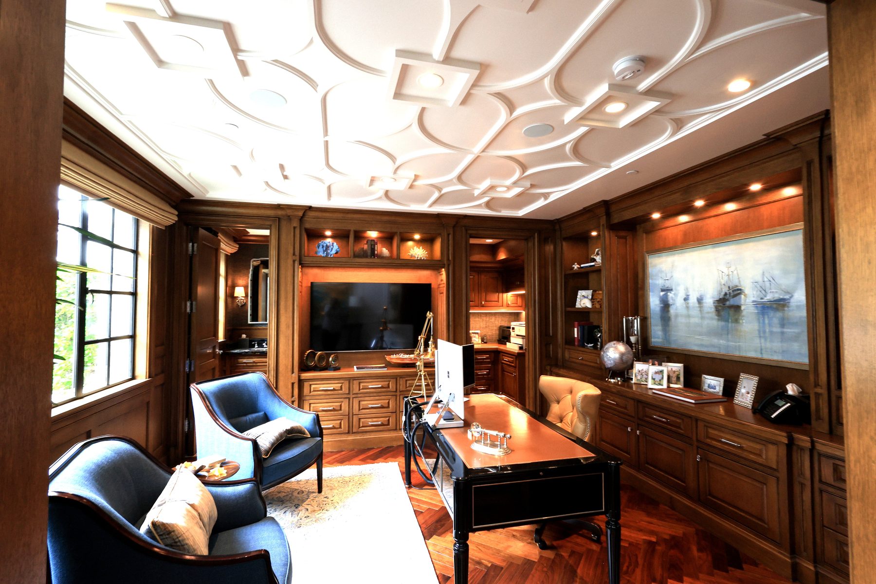 Custom wood-paneled study built-in entertainment coffered ceiling